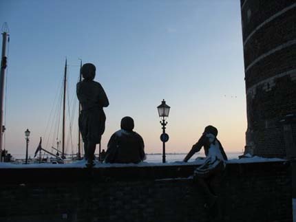 De Jongens van de Bontekoe in avondschemering uitziend over de zee.