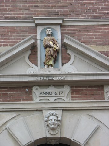Boogsegment, jaartalsteen en open fronton van Sint Pieterpoortje met ingelaten beeldje van Sint Pieter.